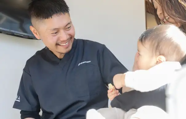 お客様のお子様を見て微笑む院長の写真