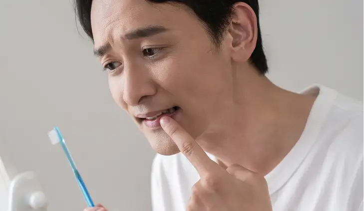 歯磨きで歯を気にする男性
